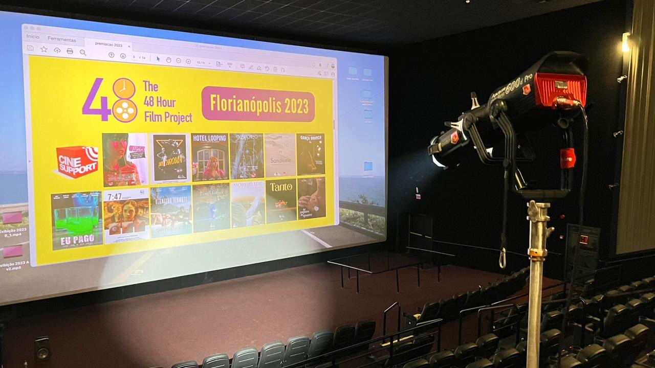Cartazes dos filmes do 48HFP Florianópolis 2023 projetados na sala de cinema